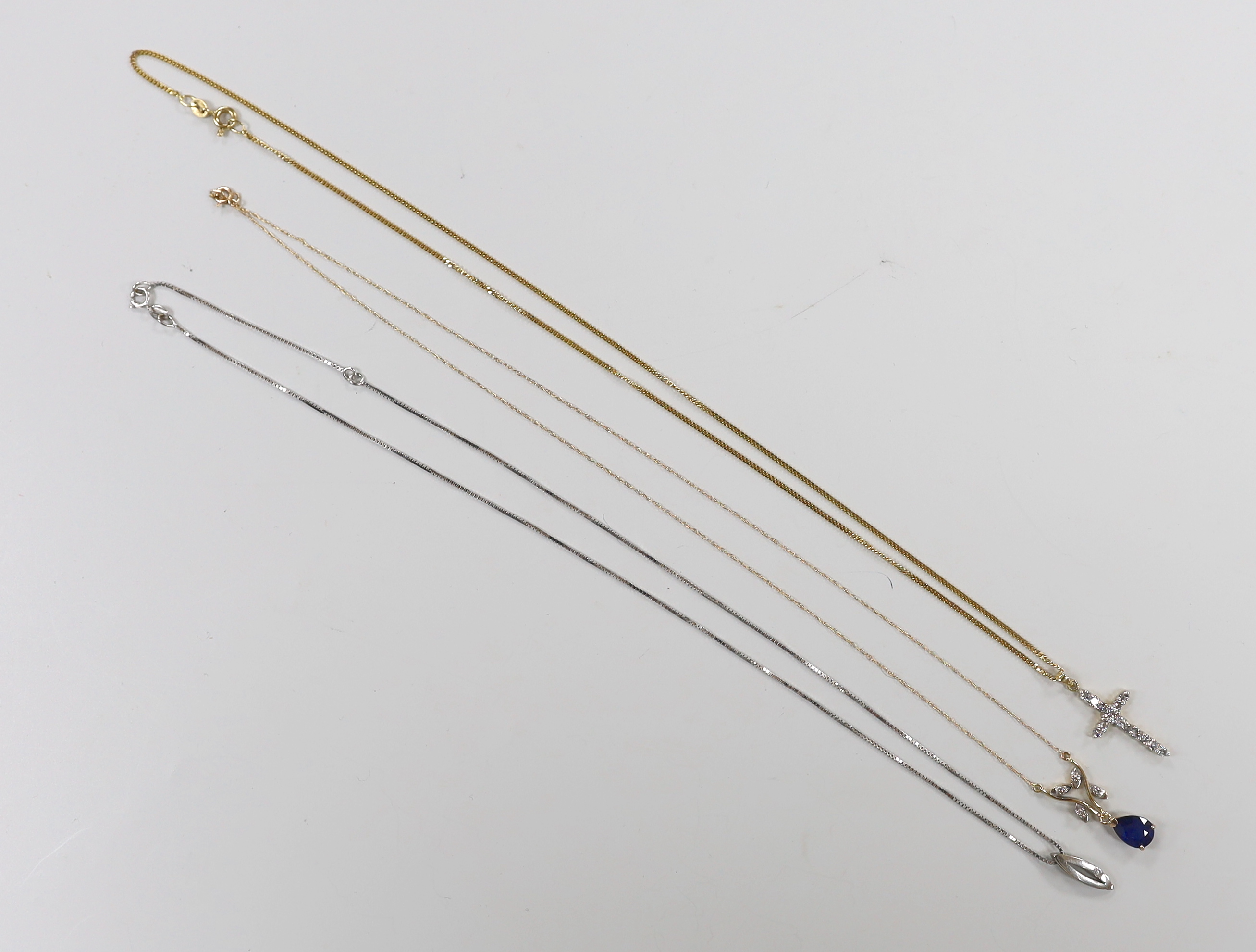 A modern 14kt yellow metal, sapphire and diamond chip set drop pendant necklace, 46cm, gross 1.6 grams, a similar 18ct gold and diamond set cross pendant, on a 9ct chain and one other 9ct and gem set pendant necklace, gr